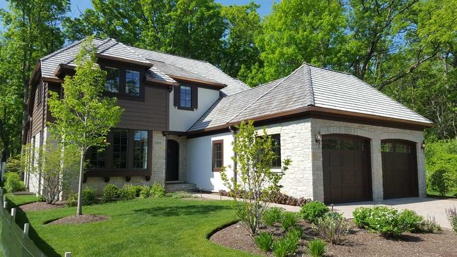 Roof on a custom home surrounded by mature trees