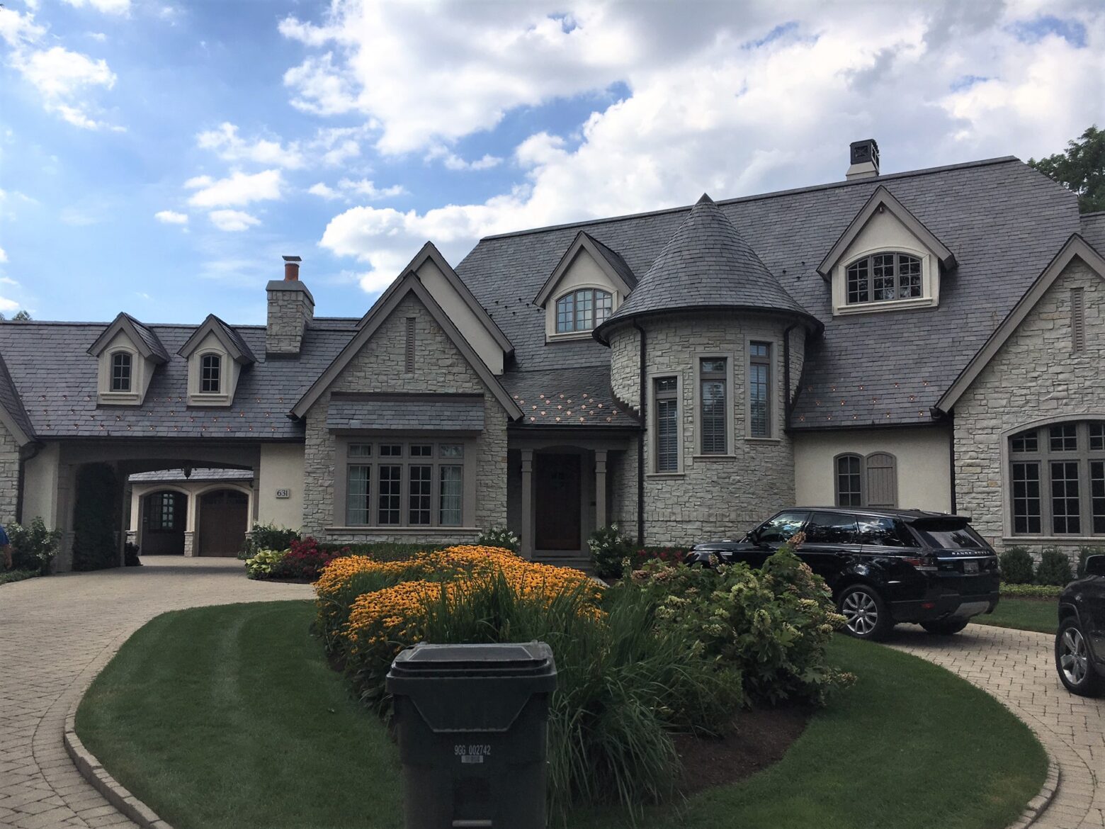 Slate roof with copper accents on a large stone home in Arlington Heights, Illinois